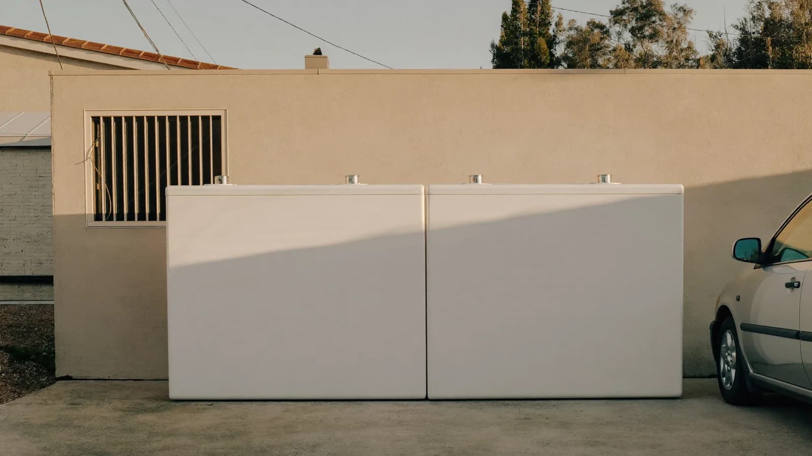 Oversized pair of home batteries dominating a small garage wall