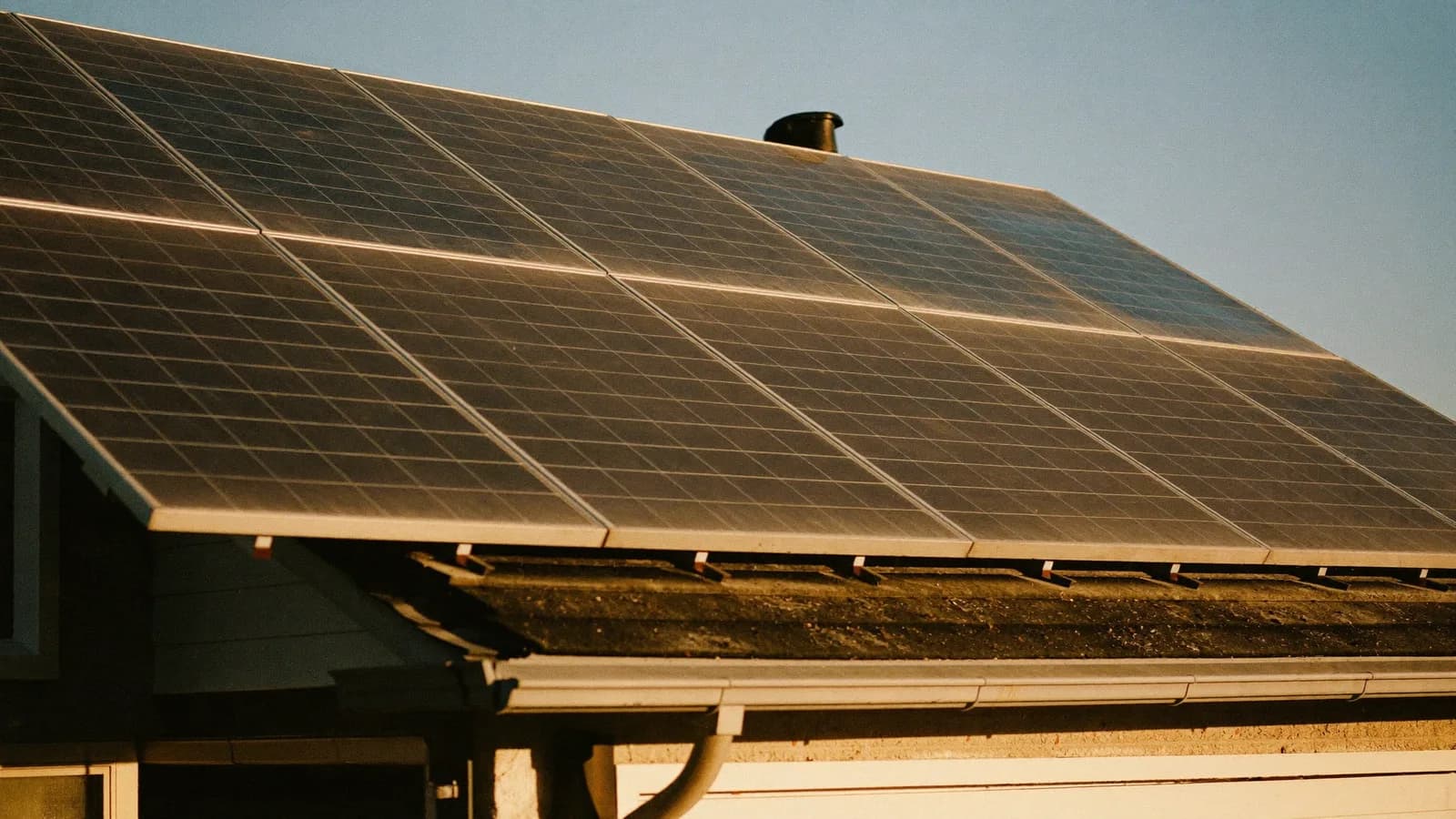 Weathered rooftop solar array still working at golden hour