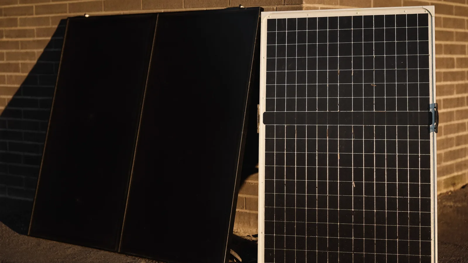 Two solar panels compared side by side against a ute in a driveway