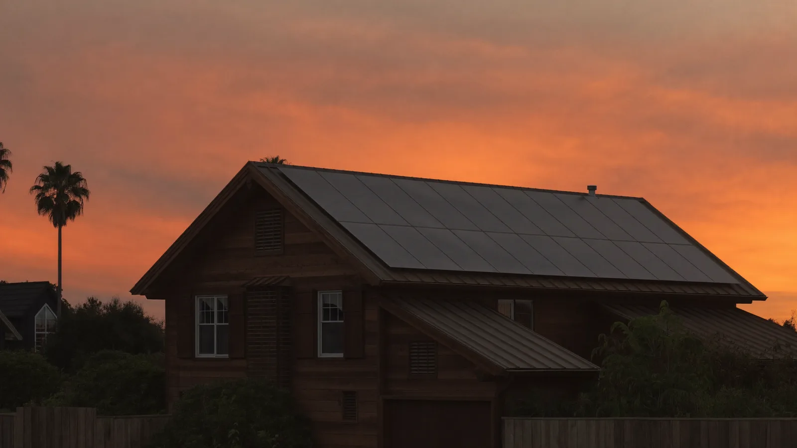 Queenslander home silhouetted at sunset with solar panels on the roof