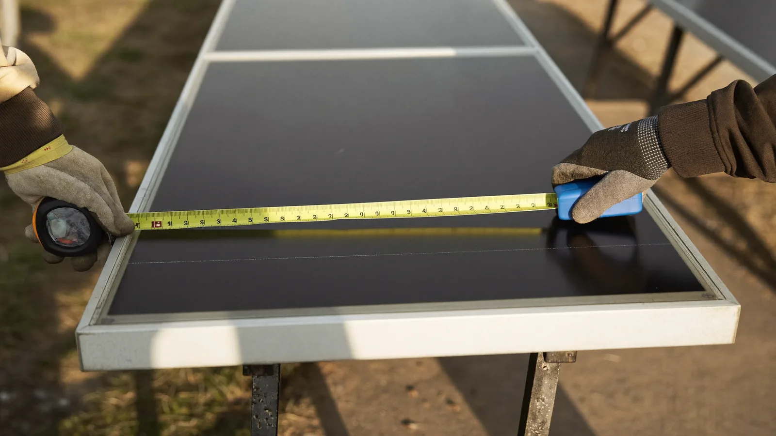 Tape measure stretched across a solar panel on trestles