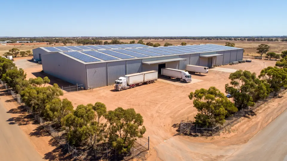 Aerial view of a large rural shed with solar panels across its roof